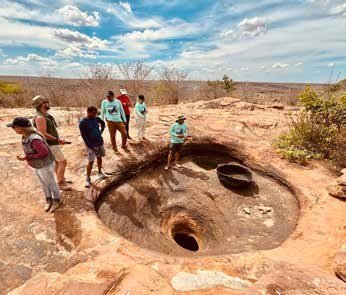 Expedicionários junto aos caldeirões de pedra.